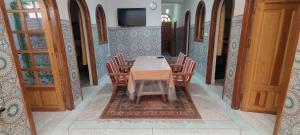 une salle à manger avec une table et des chaises et une télévision dans l'établissement Araucaria, à Essaouira 3 autres photos