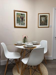 a dining room with a white table and white chairs at Luxe city stay in Ipswich +16 photos