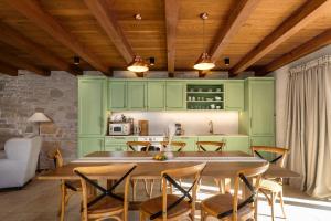 a kitchen with green cabinets and a table and chairs at Villa Paladnjaki - breakfast included in Žminj