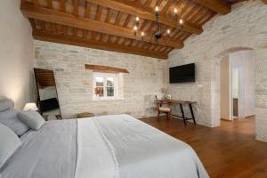 a bedroom with a large bed and a stone wall at Villa Paladnjaki - breakfast included in Žminj