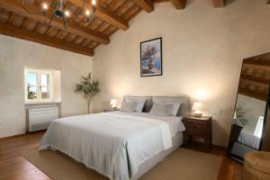 a bedroom with a large white bed and a chandelier at Villa Paladnjaki - breakfast included in Žminj