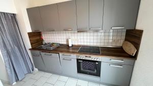 a small kitchen with white cabinets and a stove at Apartment-Luck Ilmenau in Ilmenau +9 photos