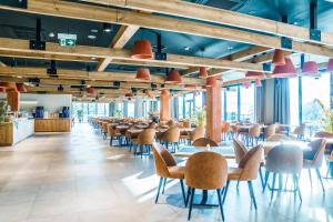 jadalnia ze stołami, krzesłami i oknami w obiekcie Elements Hotel&Spa w Świeradowie Zdroju