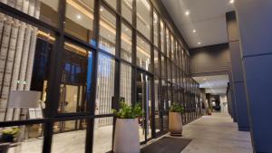 a hallway of a building with large windows and potted plants at Luxury Riverside Private Condo Bangkok North Area in Ban Sai Ma +2 photos