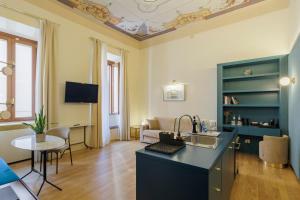 a kitchen and living room with a couch and a table at Sentho Roma in Rome