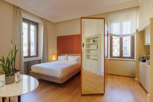 a bedroom with a bed and a table and a mirror at Sentho Roma in Rome
