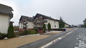 an empty street with houses on the side of the road at Brauni City Apartment in Braunlage