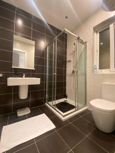 un bagno con doccia, WC e lavandino di St Julians Central Apartment a San Giuliano
