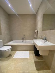 un bagno con vasca, WC e lavandino di St Julians Central Apartment a San Giuliano Altre 14 foto