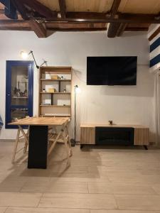a room with a table and a television on a wall at Casa Carlotta in Rio nellʼElba