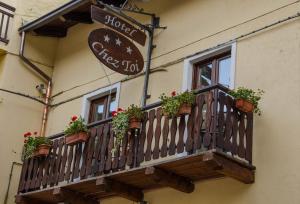 einen Balkon mit Topfpflanzen an der Seite eines Gebäudes in der Unterkunft Hotel Chez Toi in Oulx