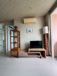 un salon avec une télévision sur un mur dans l'établissement Atlantis Condo Resort Pattaya, à Jomtien Beach