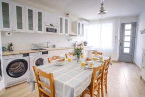 una cucina con tavolo, sedie e lavatrice di Maison Charmante au coeur de la circulade-Patio-AB a Bram