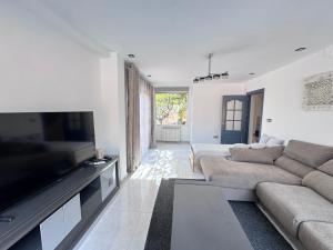a living room with a couch and a flat screen tv at VILLA T11 PREMIUM 5min PLAYA in El Campello