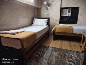 two beds in a small room with at Hotel Regal Plaza in Mumbai