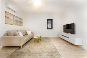 a living room with a couch and a flat screen tv at First Estates Apartment 2BR in Voluntari