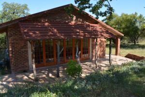 a small brick building with a roof at Guesthouse in the Waterberg in Ouklip +13 photos