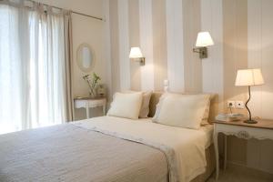 a bedroom with a bed with two lamps and a window at Kores Villas in Nydri