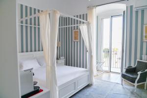 a bedroom with a canopy bed and a balcony at Le residenze del capitano in Bari +129 photos