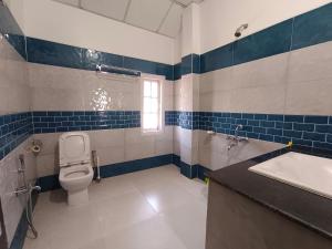 une salle de bain bleue et blanche avec des toilettes et un lavabo dans l'établissement La Nessa Resort, à Jāmb 79 autres photos