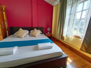 - une chambre avec un lit aux murs rouges dans l'établissement La Nessa Resort, à Jāmb