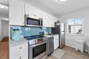 a kitchen with white cabinets and a stainless steel appliances at Plantation 3201 in Gulf Shores +35 photos