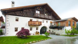 a large white building with a wooden roof at Huberhof in Natz-Schabs