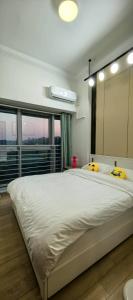 珠海Huafu Seaview Suites的卧室配有一张带黄色枕头的大型白色床。