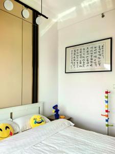 珠海Huafu Seaview Suites的一间卧室配有镜子和一张带枕头的床 更多10张照片