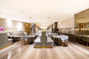 a restaurant with tables and chairs and a bar at Erian Hotel in Jakarta
