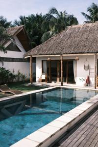 a swimming pool in front of a villa at Villa Mimpi - Bela Sulu Villas in Katiet