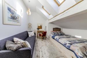 a attic bedroom with two beds and a couch at Blossom Hill Apartments in Łęcze