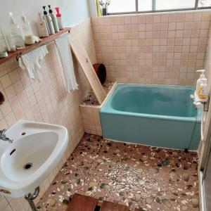 a bathroom with a tub and a sink at 民泊 inori in Dekiji