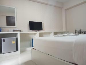 a white room with a tv and a bed at Goodview residence in Sathani Nakhon Lampang