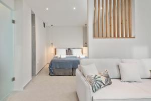 a living room with a white couch and a bed at Theofania by Vintage Travel in Gouvia +17 photos