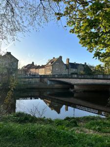 a bridge over a river with buildings in the background at Town center cottage with Hot tub in Morpeth