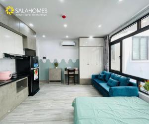 a living room with a blue couch and a kitchen at Salahomes Apartment by Dapano in Hanoi
