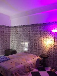 a bedroom with a bed and a purple lighting at Maison de la paix in Casablanca