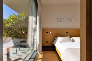 a bedroom with a bed and a table and a window at Apartmaji Guerila in Ajdovščina +9 photos