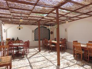 a dining room with wooden tables and chairs at Villa Nile House Luxor in Luxor