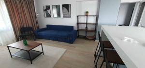a living room with a blue couch and a table at Bella Vista Primavera 1124 in Bucharest