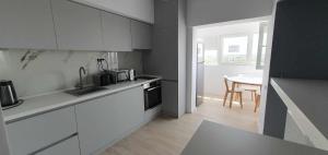 a kitchen with white cabinets and a table in a room at Bella Vista Primavera 1124 in Bucharest