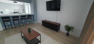 a living room with a table and a tv on a wall at Bella Vista Primavera 1124 in Bucharest