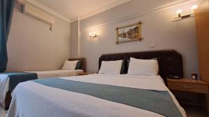 乔尔卢Elite Hotel City Center Corlu Bed and Breakfast的酒店房间有两张床，床单是白色的