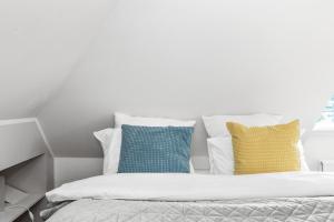 セールフォスにあるTo be Remove Venture Vacations-Golden Circle Hot Tub Cabinのカラフルな枕と白い壁のあるベッド