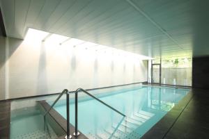a large swimming pool with a stair in a building at Hotel Spa Niwa in Brihuega