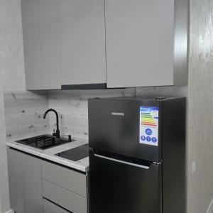 eine Küche mit einem Kühlschrank aus Edelstahl und einem Herd in der Unterkunft ЖК Панорама Парк in Qostanai