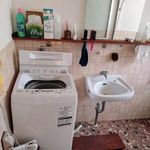 a dirty bathroom with a washing machine and a sink at 民泊 inori in Dekiji +8 photos