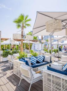 a patio with chairs and an umbrella and palm trees at Radisson Beach Resort Palm Jumeirah in Dubai