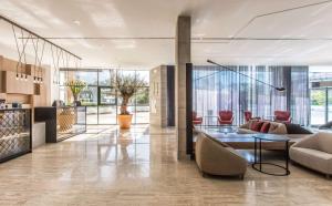 a living room with a table and chairs at NH Sevilla Plaza de Armas in Seville +104 photos